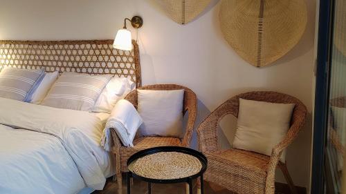 um quarto com uma cama e 2 cadeiras de vime em Estudio con Encanto en Navacerrada em Navacerrada