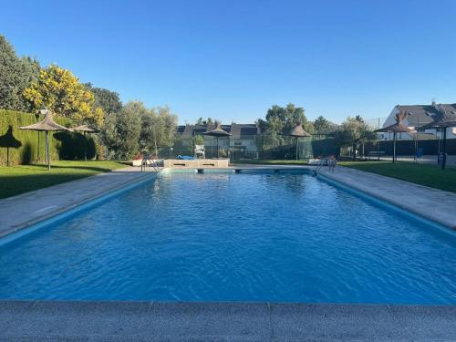een groot blauw zwembad in een park bij Estudio con Encanto en Navacerrada in Navacerrada