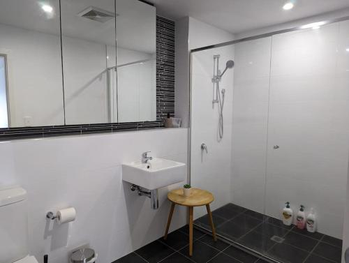 a white bathroom with a sink and a shower at Modern & Relaxed Apartment, Great Views @Wright in Weston Creek