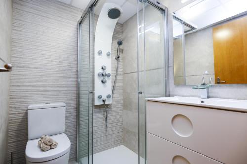 uma casa de banho com um chuveiro, um WC e um lavatório. em New Bruselas 1 Planetcostadorada em Cambrils