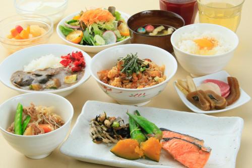 einen Tisch mit Schalen verschiedener Arten von Lebensmitteln in der Unterkunft Richmond Hotel Narita in Narita
