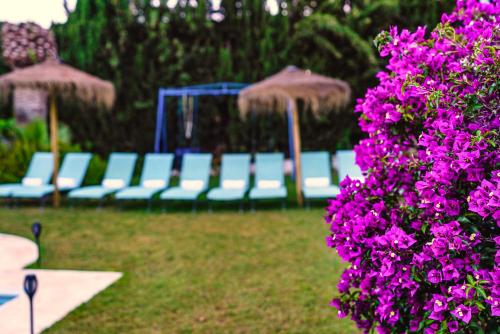 een groep blauwe stoelen en paarse bloemen bij Villa 10 Luxe by Lirios Village Marbella in Marbella