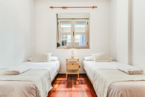 2 camas individuales en una habitación con ventana en Home2Book Comfy Apartment Las Palmas Center Triana, en Las Palmas de Gran Canaria