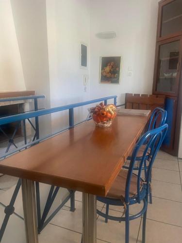 a wooden table with a bowl of fruit on it at Periyali in Keratea