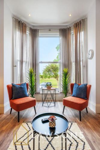 a living room with two chairs and a table at 3-Bed, 3-Bath Apartment with Southsea Common Views in Portsmouth