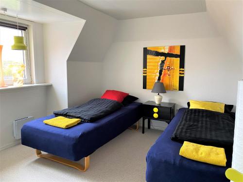 1 dormitorio con 2 camas y mesa con lámpara en Event4U en Nykøbing Mors
