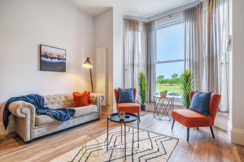a living room with a couch and chairs and a large window at 3-Bed, 3-Bath Apartment with Southsea Common Views in Portsmouth