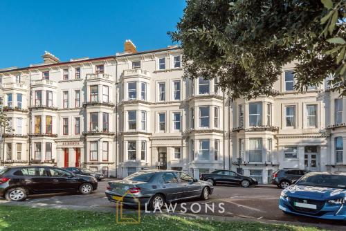 a large white building with cars parked in front of it at 3-Bed, 3-Bath Apartment with Southsea Common Views in Portsmouth