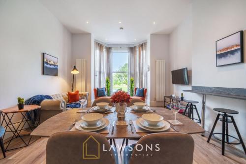 a living room with a table and chairs in a room at 3-Bed, 3-Bath Apartment with Southsea Common Views in Portsmouth