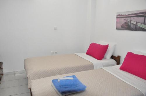 a room with two beds with red and pink pillows at Periyali in Keratea