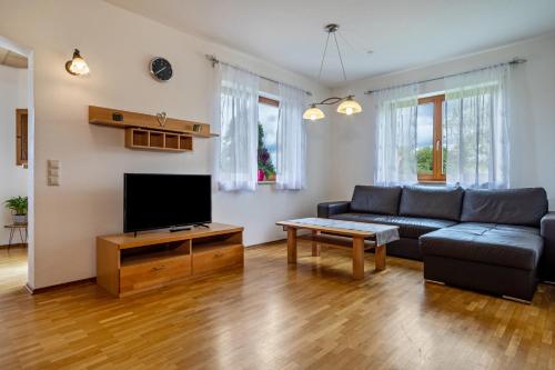 a living room with a couch and a tv at Drei-Mädelhaus Ambs Wohnung 2 in Gornhofen
