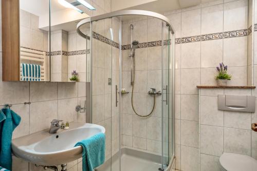 uma casa de banho com um lavatório e um chuveiro em Drei-mädelhaus Ambs Wohnung 2 