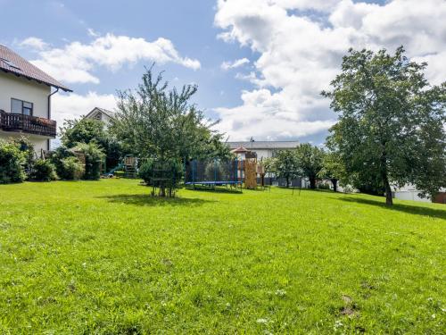 a grassy yard with two trees and houses at Drei-Mädelhaus Ambs Wohnung 2 in Gornhofen