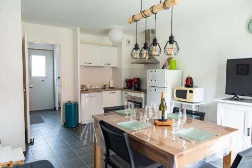 une cuisine avec une table avec des verres à vin dessus dans l'établissement Les Lofoten : Maison neuve Résidence Sequoia, à Saint-Valery-sur-Somme