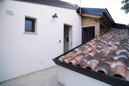 a tile roof on a white building with a door at Casa Marinari in Scalea