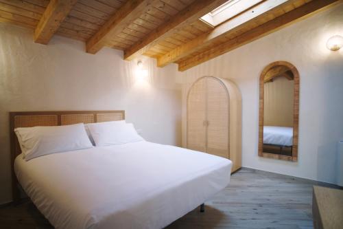 a bedroom with a white bed and a mirror at Casa Marinari in Scalea