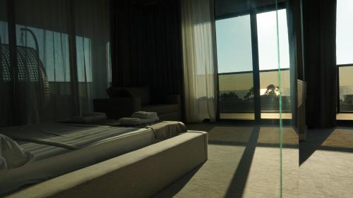 a hotel room with a bed and a large window at Hotel Nobilis Hall in K'obulet'i