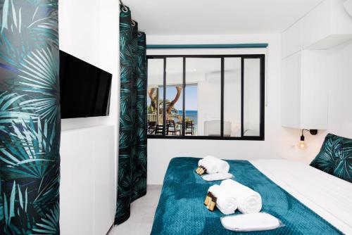- une chambre avec un lit, des serviettes et une télévision dans l'établissement Fettolina, à Cannes