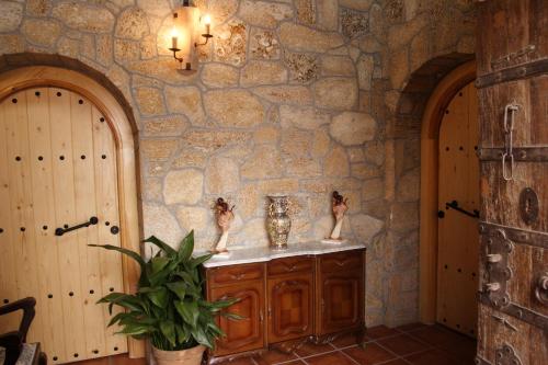 baño con pared de piedra y encimera con fregadero en Cuevas las Chimeneas, en Guadix