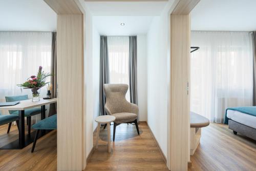 a room with a bed and a desk with a chair at Hotel Villa Flora in Velden am Wörthersee