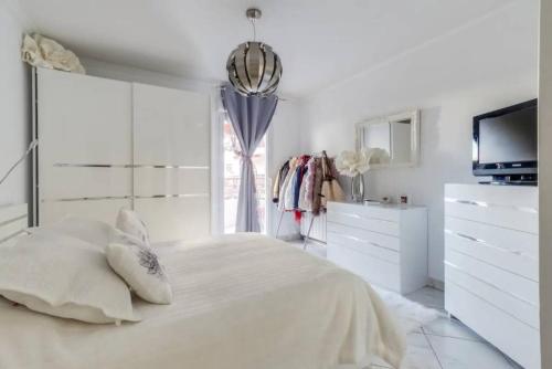 une chambre blanche avec un lit et une télévision dans l'établissement Magnifique 4 pers plage à pied, à Fréjus