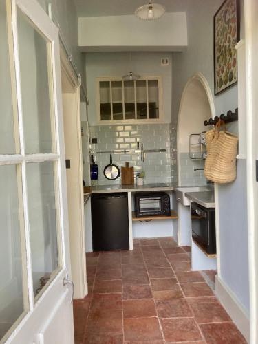 Il comprend une cuisine dotée de carrelage et d'une grande fenêtre. dans l'établissement Gogascony, à Lavit