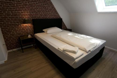 a bed in a room with a brick wall at P8 Ferienwohnung in Remscheid