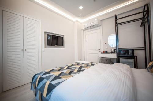 a bedroom with a bed and a tv on the wall at Megalos Galata Hotel in Istanbul