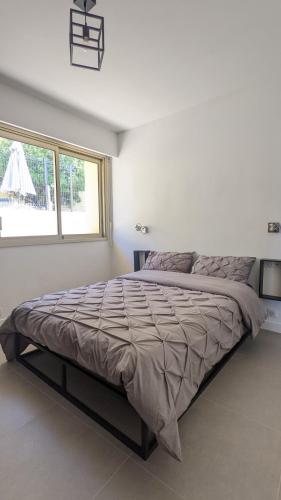 Cette chambre blanche dispose d'un grand lit et d'une fenêtre. dans l'établissement 3 pièces dans villa avec piscine, à Nice