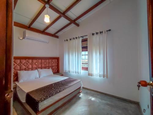 Un dormitorio con una cama grande y una ventana en Peacock Village Pinnawala, en Pinnawala