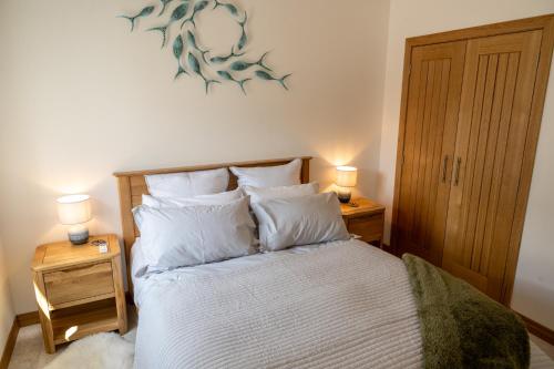 ein Schlafzimmer mit einem Bett mit zwei Lampen an Tischen in der Unterkunft Lily Cottage - 1 bedroom in Forres