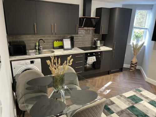 a kitchen with a glass table and chairs and a sink at Southbank Stays Premium Apartment - Sleeps 4 in Coventry