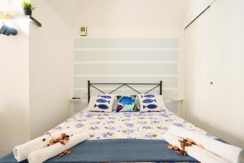 een slaapkamer met een bed met blauwe en witte lakens en kussens bij La casetta delle barche in Riomaggiore