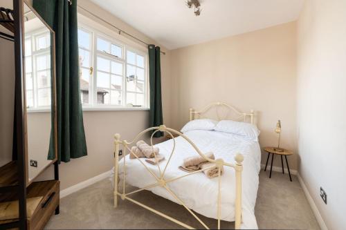 a bedroom with a white bed and a window at Tranquil 3BD Haven by the Sea in Littlehampton in Littlehampton