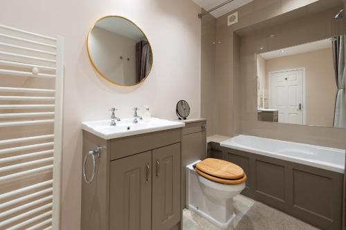 a bathroom with a toilet and a sink and a mirror at Tranquil 3BD Haven by the Sea in Littlehampton in Littlehampton