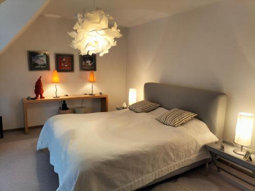 een slaapkamer met een groot wit bed met 2 kussens bij Großzügig-Wohnen nahe Erlangen - Nürnberg in Dormitz