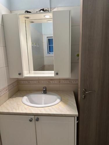 ein Bad mit einem Waschbecken und einem Spiegel in der Unterkunft Vergi Apartments in Pyla