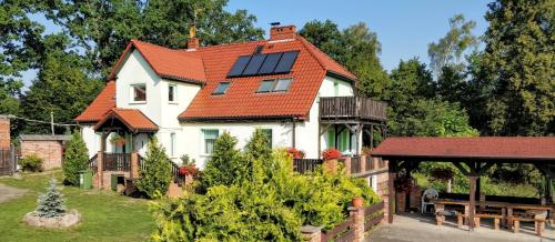 a house with solar panels on its roof at Gospodarstwo Agroturystyczne Bukowy Jar in Połczyn-Zdrój