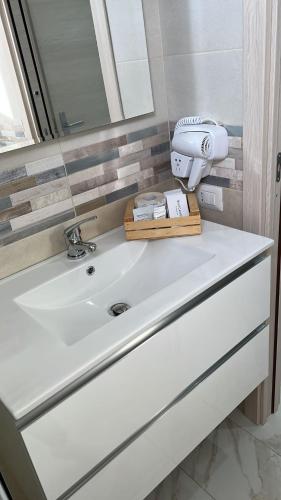 bagno con lavandino bianco e specchio di B&b PAESTUM ROOM a Paestum