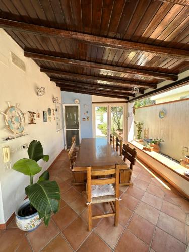 ein Esszimmer mit einem Tisch und einer Pflanze in der Unterkunft Villa San Leo in San Leone