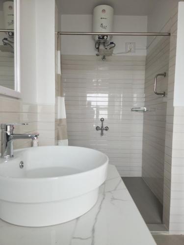 een witte badkamer met een wastafel en een douche bij Unit 5 in Aizawl