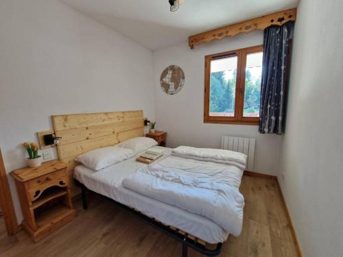 a small bedroom with a bed and a window at Bel appartement avec piscine - Le Grand Tétras in Samoëns