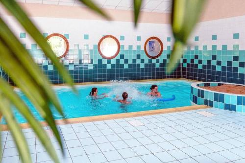 three people swimming in a swimming pool at Bel appartement avec piscine - Le Grand Tétras in Samoëns