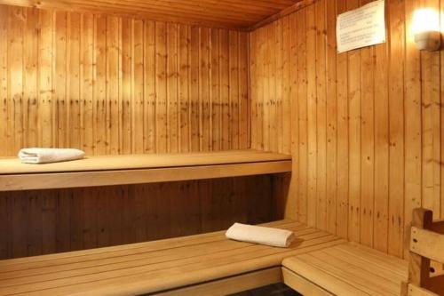 a wooden sauna with two towels on a shelf at Bel appartement avec piscine - Le Grand Tétras in Samoëns