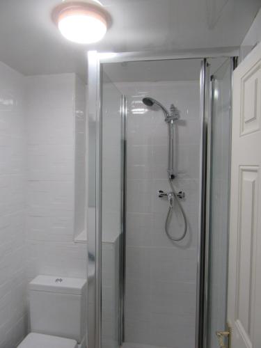 a bathroom with a glass shower with a toilet at RK Heritage House in Birmingham