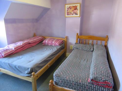 2 camas en una habitación con paredes moradas en RK Heritage House en Birmingham
