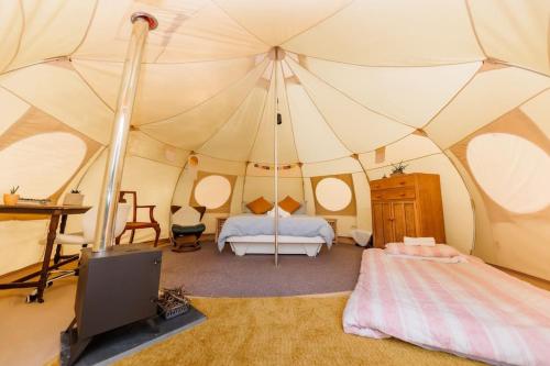 a bedroom with a tent with a bed and a tv at South Devon Luna Bell Tent in Newton Abbot