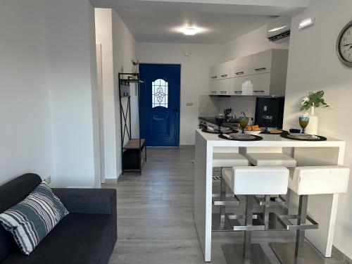 eine Küche und ein Wohnzimmer mit einer Theke und einem Tisch in der Unterkunft Kato Zaros Apartments in Zarós