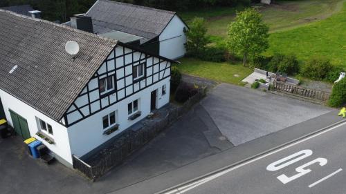 an overhead view of a white house with a parking lot at Lochhof Zwei - Eifelurlaub mit Farmcharme in Hellenthal