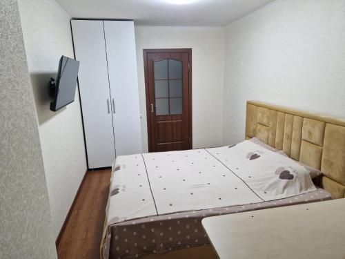 a bedroom with a large bed with a wooden headboard at Апартаменты в тихом месте in Chişinău